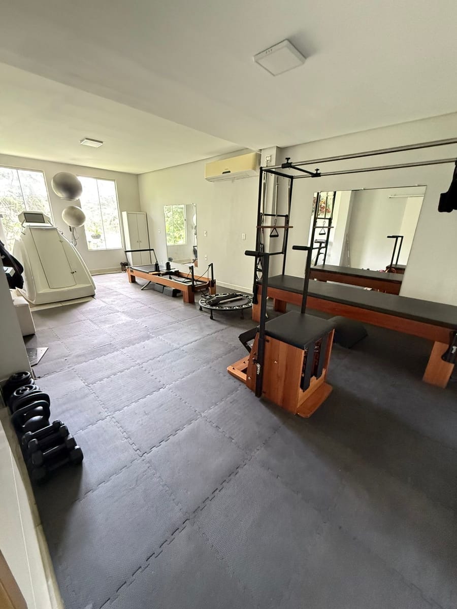 Sala de treino do Instituto Qualitté com aparelhos de pilates e a cápsula emagrecedora ao fundo