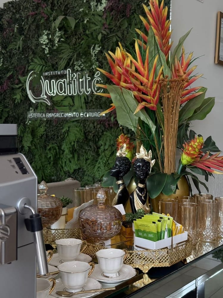 Mesa de café da recepção com flores tropicais e a logo do Instituto ao fundo