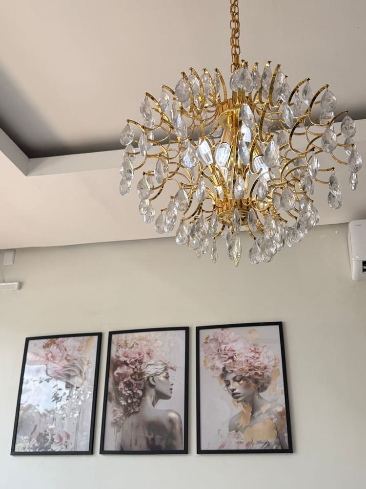 Lustre de cristal e quadros florais na decoração do Instituto